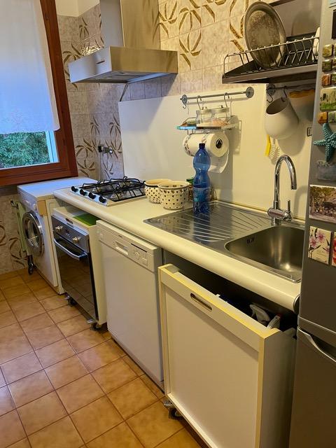 Ecco come era la cucina prima, con i mobili staccati, gli elettrodomestici a vista, le piastrelle originali della casa anni 60, il serramento color legno marrone. La disposizione andava bene, ma lo stile era da rivedere e soprattutto ci volevano dei mobili più funzionali. La cappa è stata smontata  per essere riutilizzata, cosi come i fuochi e il forno. Anche il frigo free standing è stato riutilizzato: era ancora in ottima condizione.