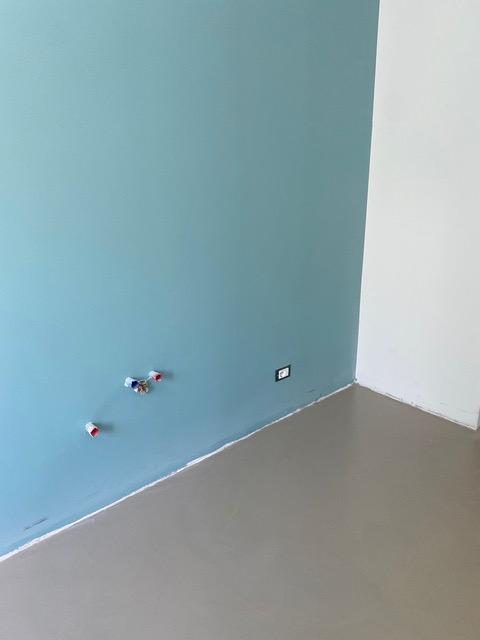 Come prima cosa è stata fatta una resina color sabbia sul pavimento, che ha evitato di dover demolire il pavimento esistente, e sono state dipinte tutte le pareti di bianco tranne quella dietro al bancone operativo, dove è stato scelto un azzurro intenso.