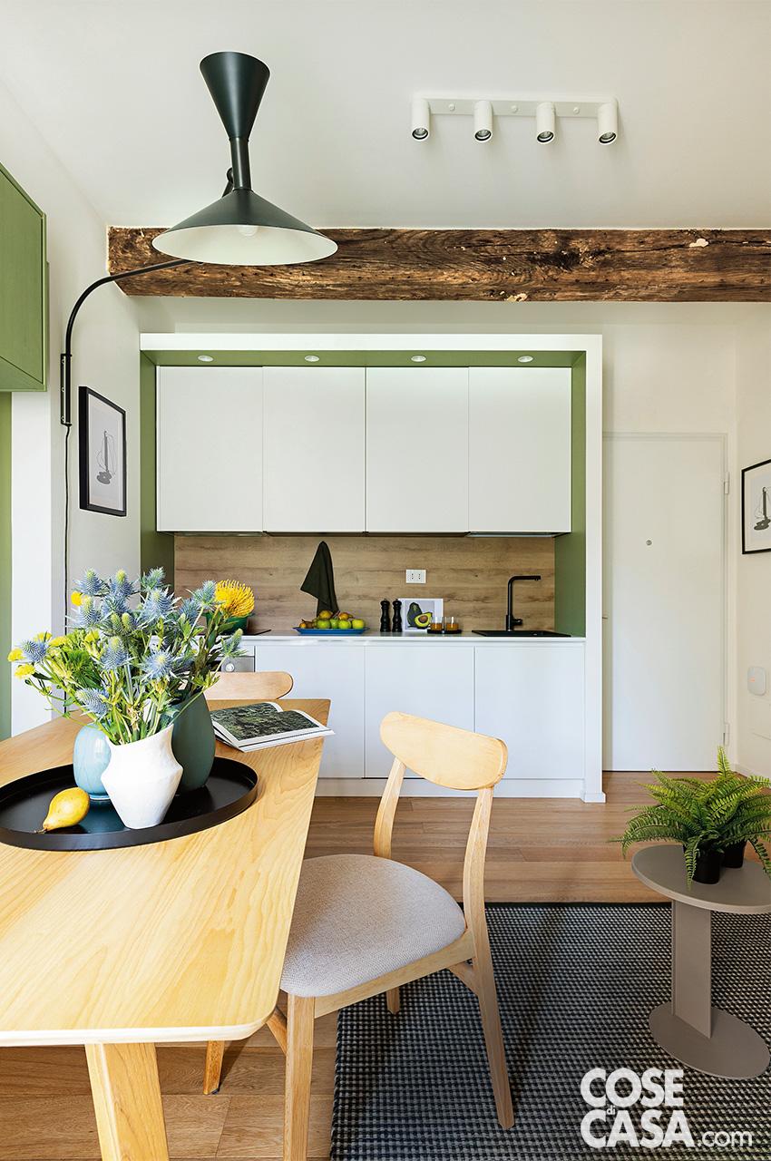 Nella zona cottura, la cornice laterale e superiore in mdf laccato bianco è stata realizzata su disegno dal falegname. Basi e pensili della cucina sono della serie Aura di Home Cucine. Forno multifunzione, lavastoviglie e piano cottura sono della Serie 4 di Bosch. Il lavello da 45 cm in fragranite è Quadra, il miscelatore monocomando girevole è Trail, tutto di Elleci. La barra con quattro faretti cilindrici è Nimane di Ikea. Il piano è illuminato dall'applique orientabile Lampe de Marseille di Nemo Lighting, design Le Corbusier. I vasi sono di Zara Home e di Asa Selection.