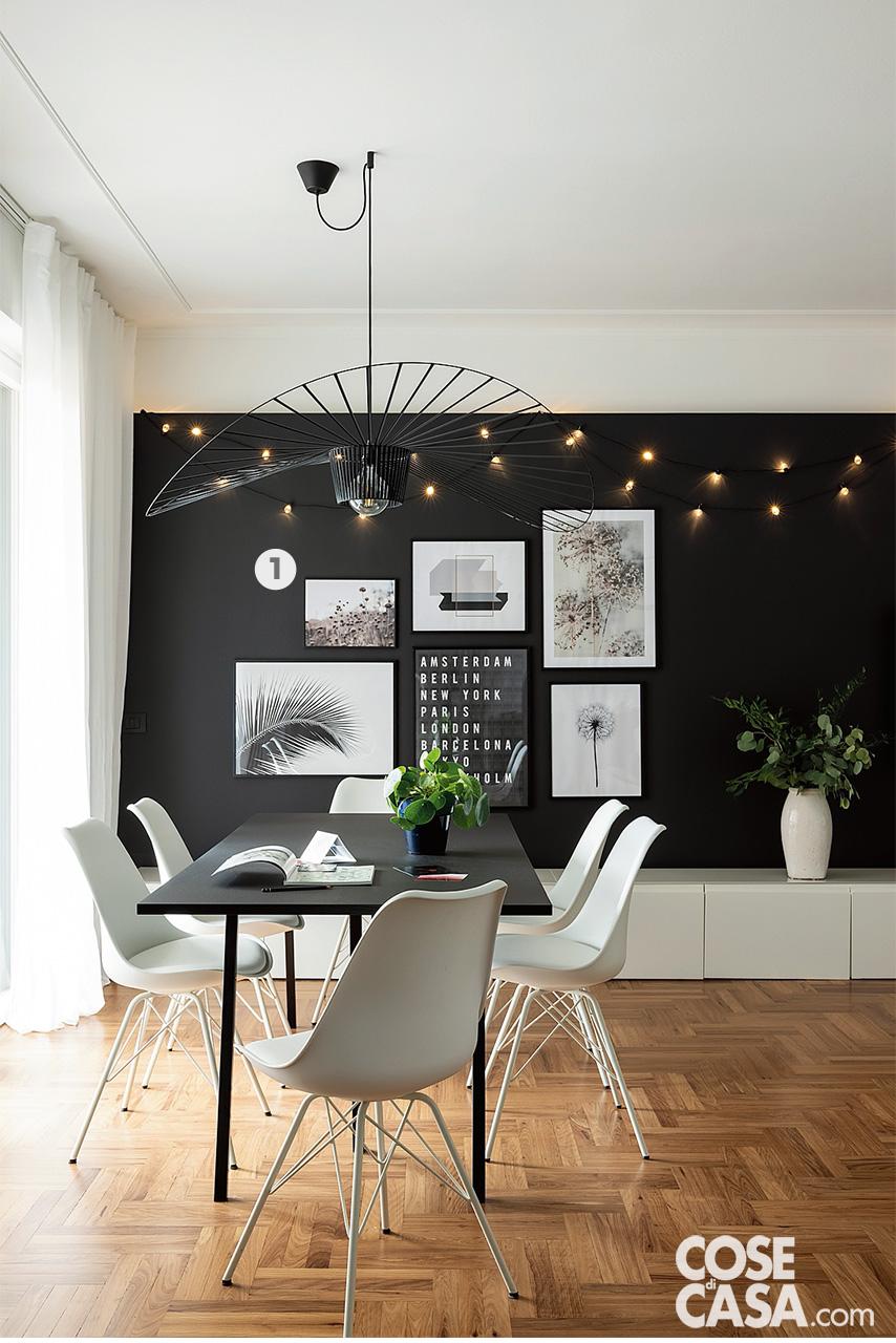 zona pranzo con tavolo rettangolare nero e sedie bianche
