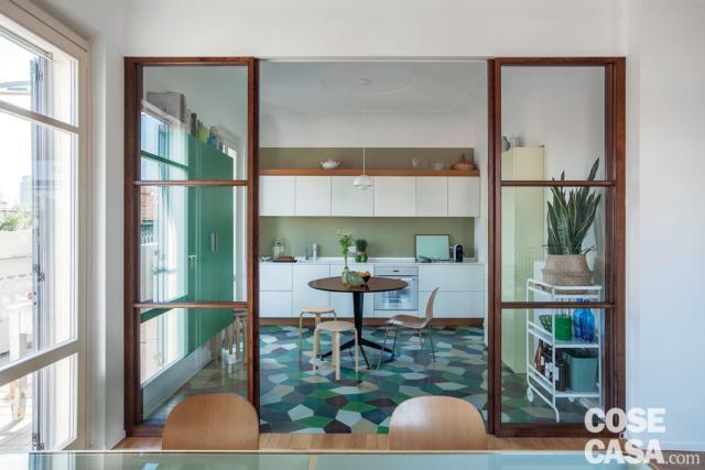 Cucina abitabile, separata da una vetrata. I mobili bianchi sono valorizzati dal pavimento colorato e dai profili delle porte a tutta altezza. Cucina abitabile, separata da una vetrata. I mobili bianchi sono valorizzati dal pavimento colorato e dai profili delle porte a tutta altezza.