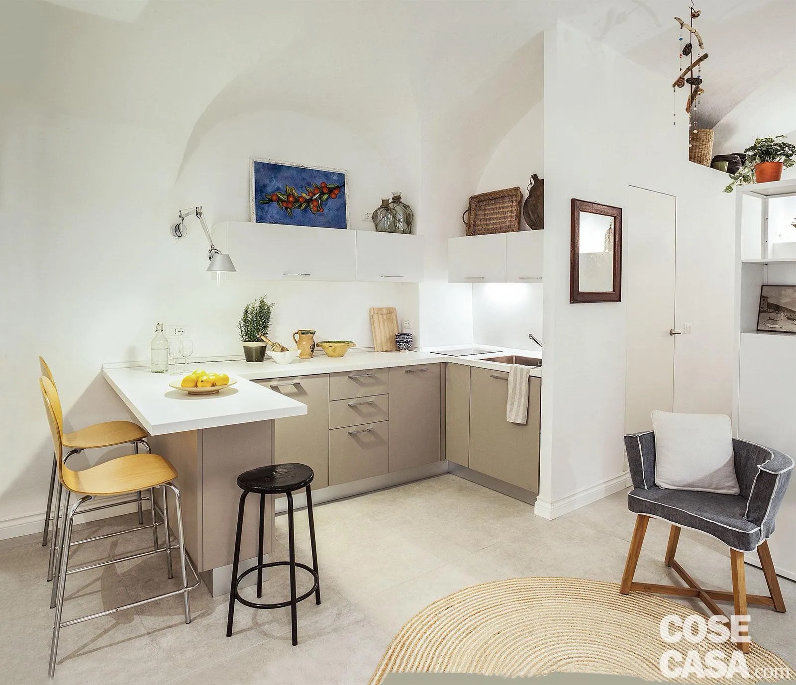 Cucina a ferro di cavallo color sabbia con top bianco aperta sul soggiorno. Cucina a ferro di cavallo color sabbia con top bianco aperta sul soggiorno.