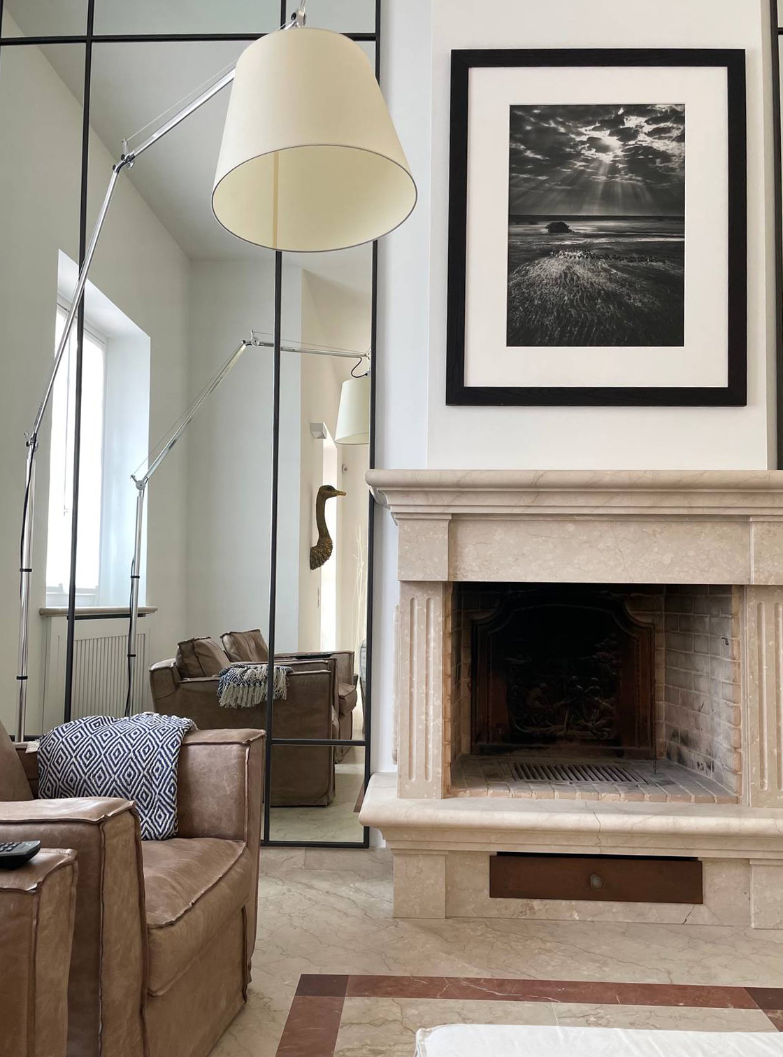 cornice della foto nera abbinata al profilo in ferro nero di uno specchio a fianco al camino