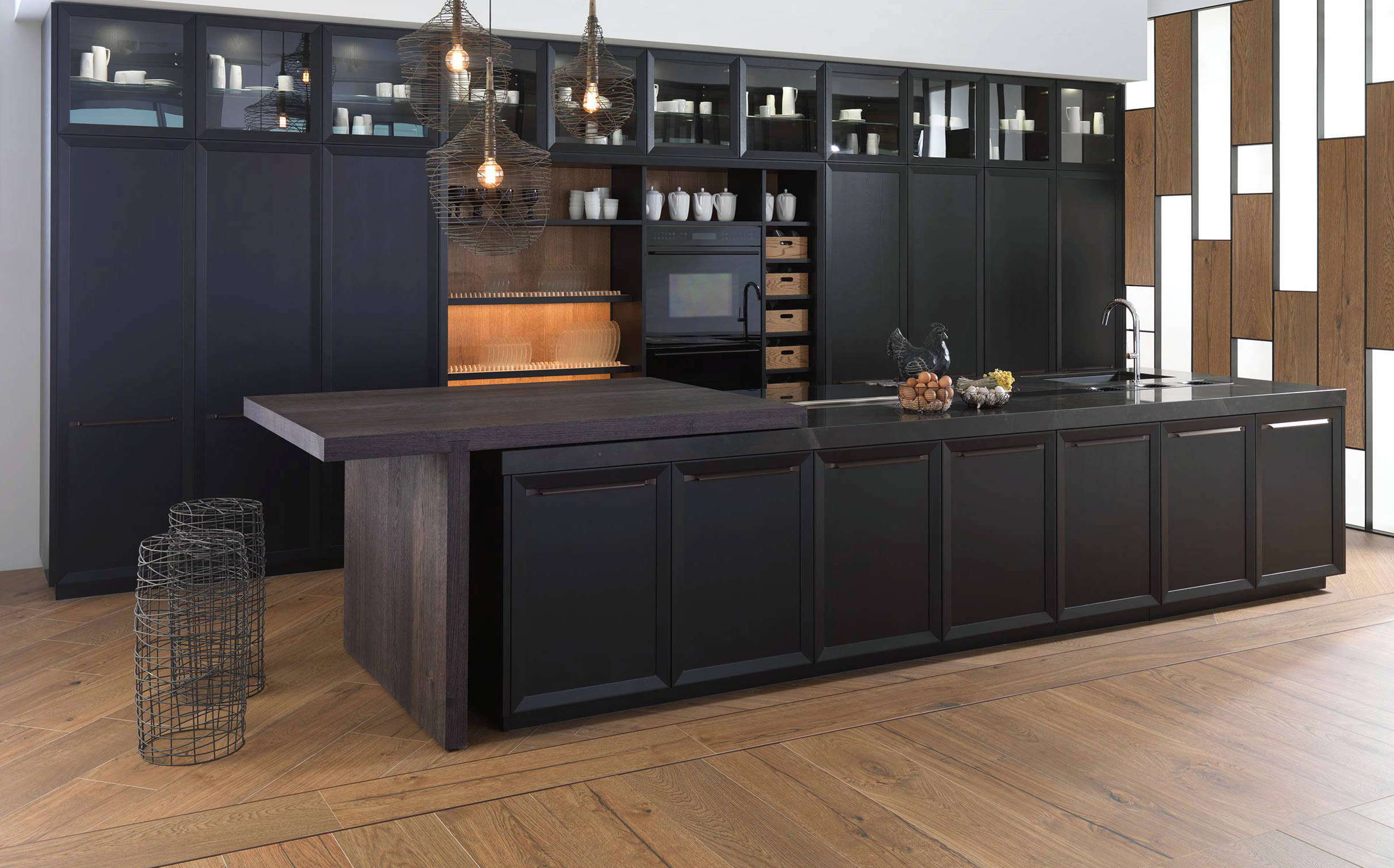 Un'intensa colorazione scura per le ante a telaio in legno di quercia che caratterizzano le basi e le colonne della cucina E 4.40 Negro Emotions di Gamadecor. La lunga isola centrale è dotata di un tavolo, posizionato lateralmente e può essere esteso e ruotato in base alle esigenze. Prezzo su richiesta. www.gama-decor.com