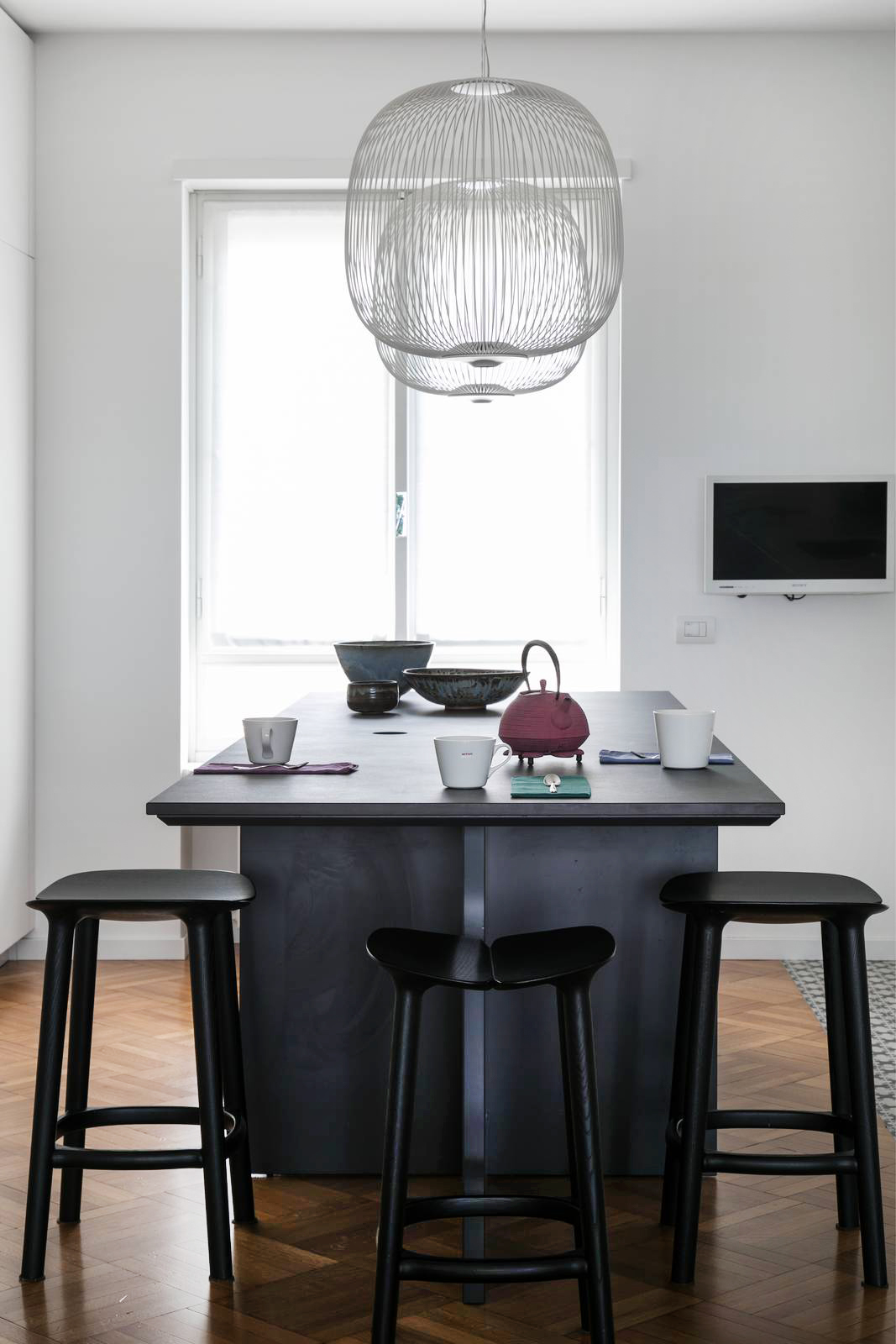 l’isola al centro della cucina con gli sgabelli neri