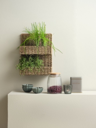 Ispirazione coloniale per lo scaffale da parete Lau di Jysk che permette di tenere in bellavista in cucina le piantine aromatiche e piccoli accessori; è completamente realizzato con alghe marine intrecciate su un telaio in acciaio che ne sottolineano l'aspetto naturale ed ecologico. Misura L 28 x P 12 x H 36 cm. Prezzo 16,95 euro. www.jysk.it