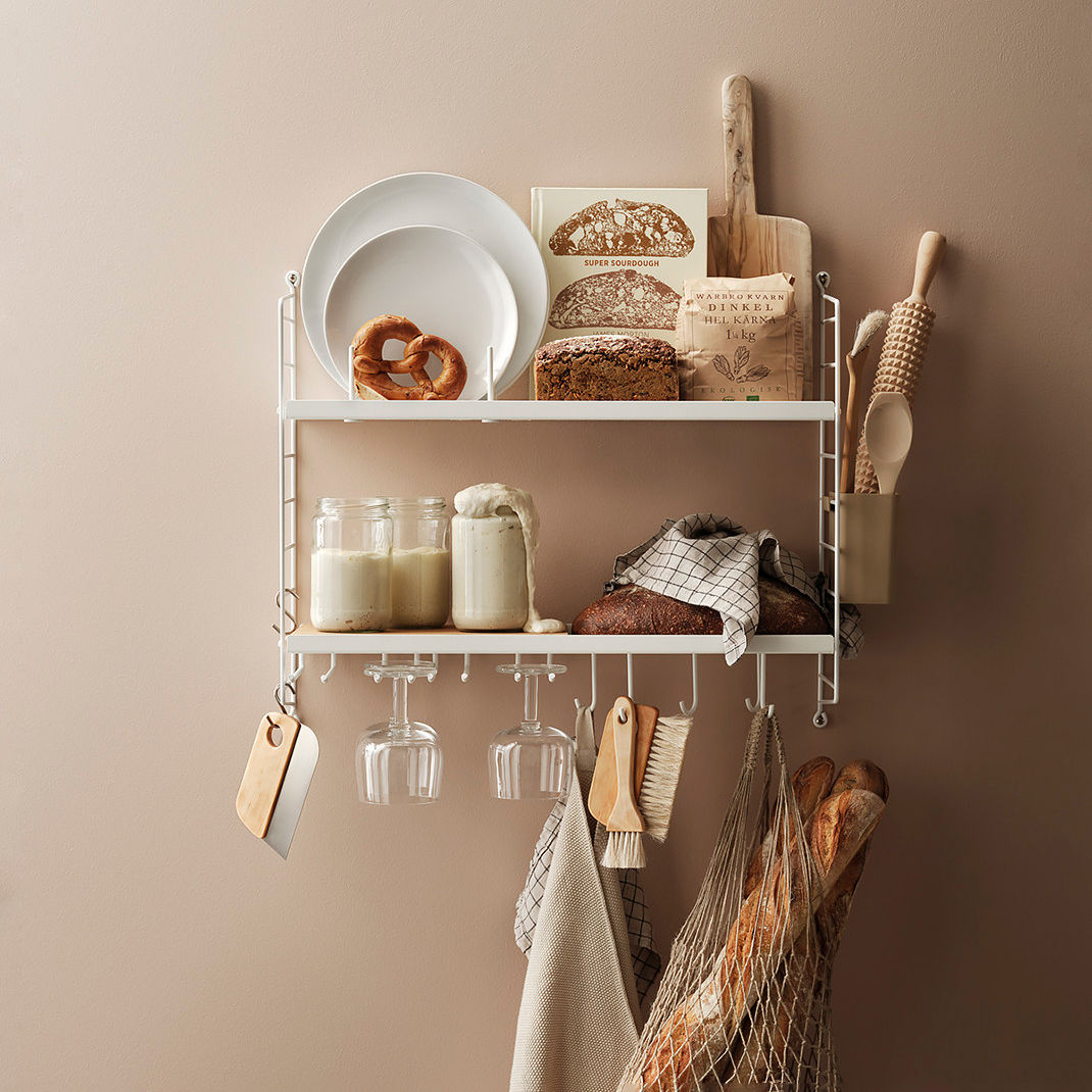 Permette di sfruttare lo spazio sulla parete lo scaffale componibile String Kitchen in vendita su Made in Design che è caratterizzato da un design nordico e che può essere combinato in base alle esigenze. È corredato di un ripiano in acciaio verniciato a polvere bianco, di un vano portaoggetti in bioplastica beige e da una base in sughero e include uno scolapiatti, due portabicchieri e da una serie di ganci portatutto. Misura L 58 x P 20 x H 50 cm. Prezzo 461 euro. www.madeindesign.it