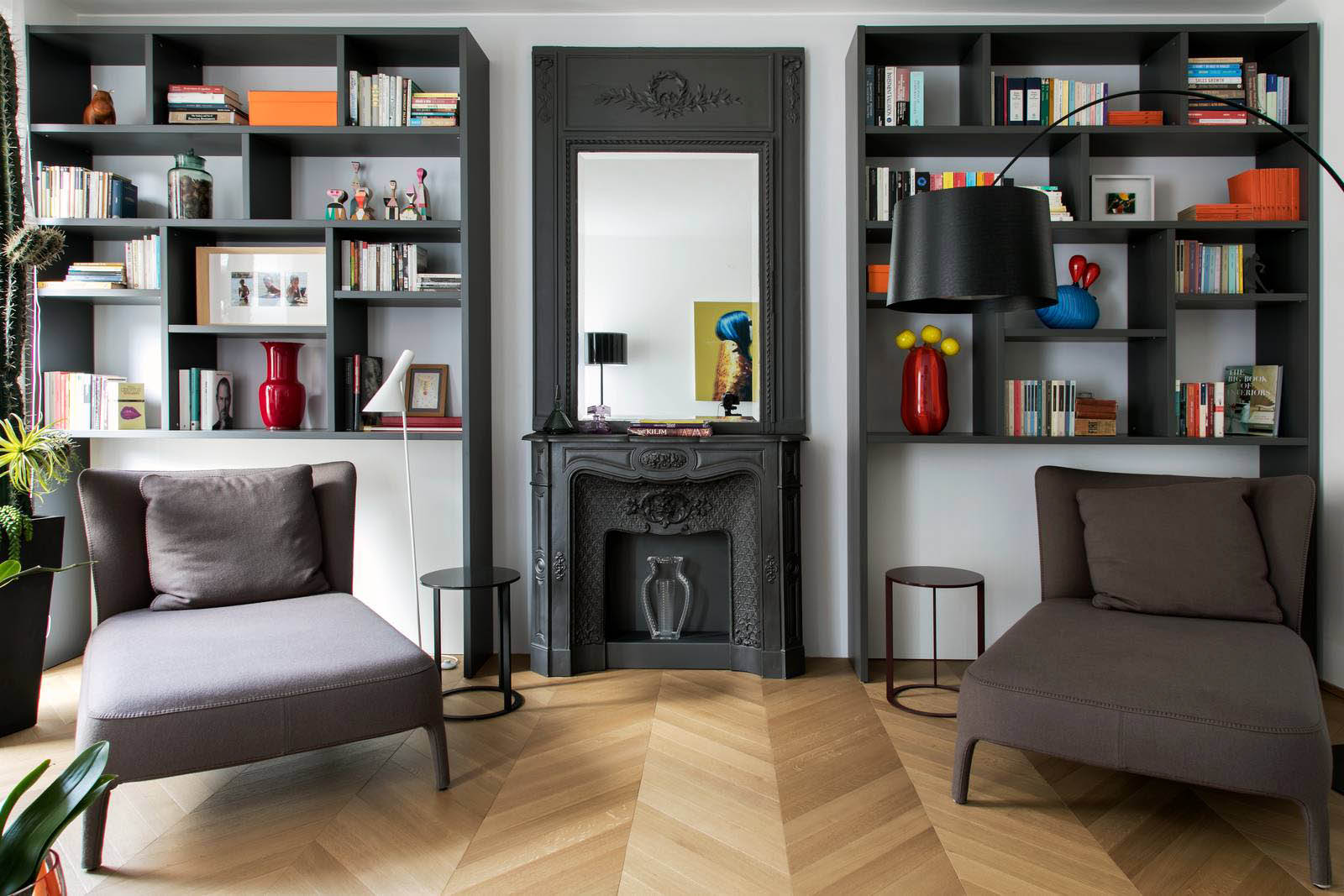 soggiorno con libreria nera, camino e specchio