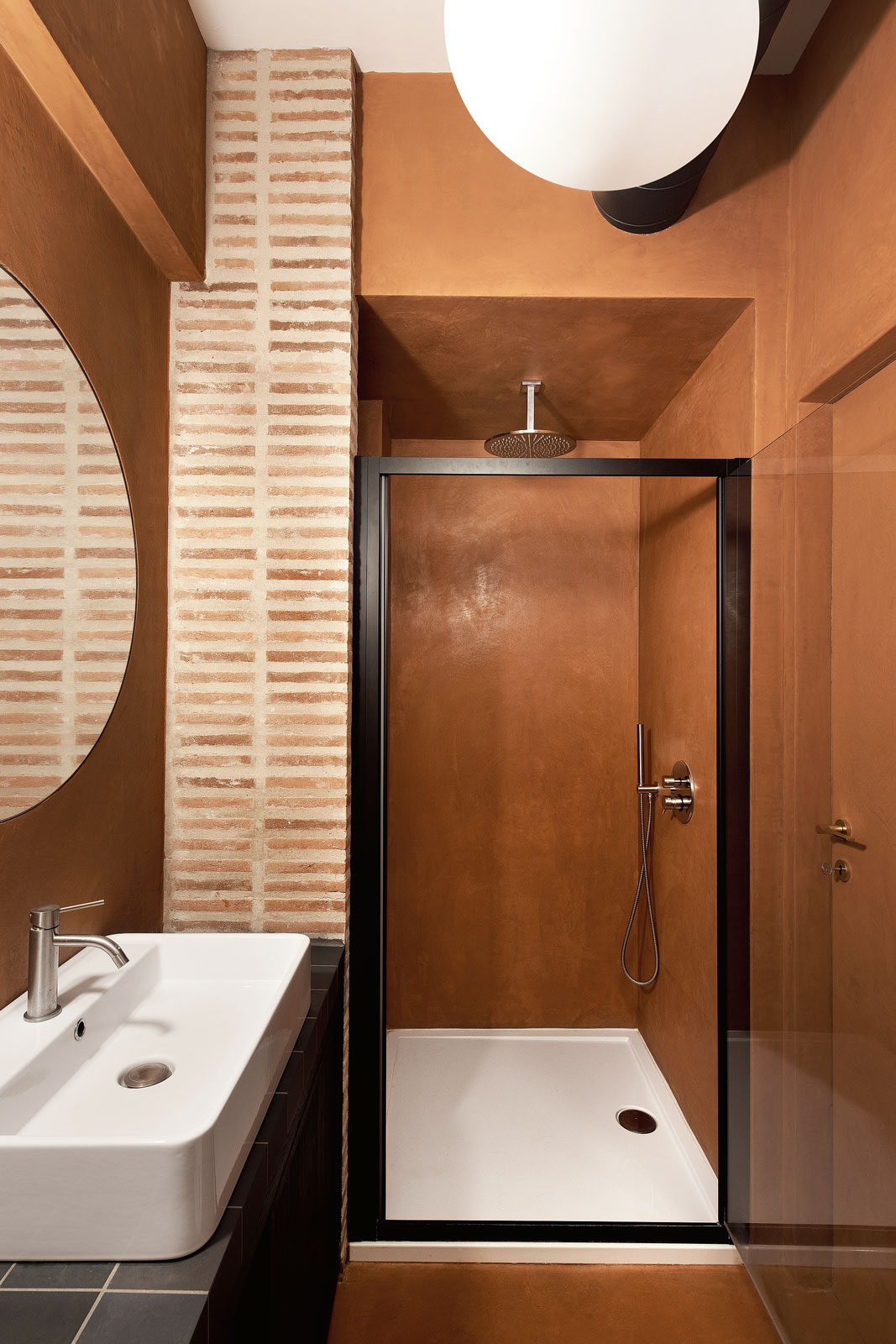 BAGNO 2 - In questo locale è stata invece prevista la doccia, con dei profili neri come le piastrelle del top e come il mobile bagno. La lavorazione in cocciopesto impermeabile delle pareti del bagno
è stata eseguita argianalmente. All'interno del box doccia in muratura, il ribassamento in cartongesso green di oltre 40 cm contiene l'impianto di ventilazione meccanica del bagno cieco.