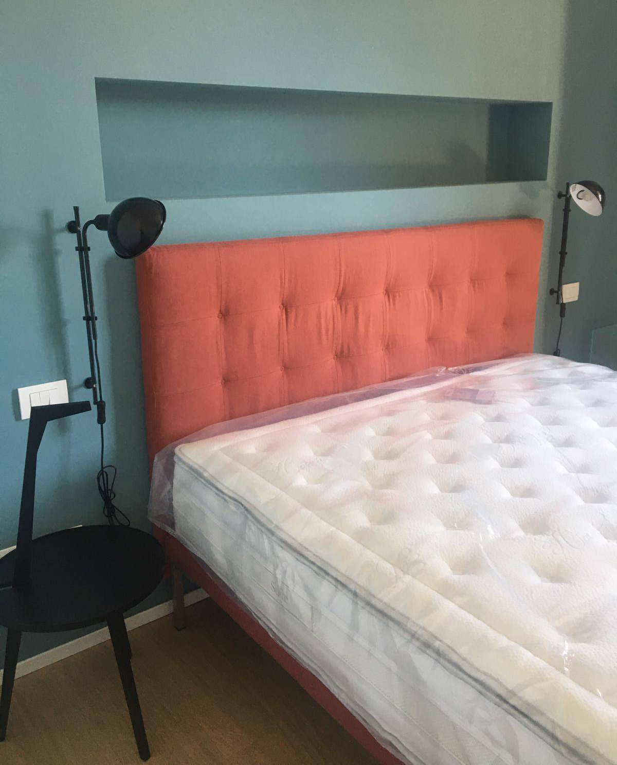 Una nicchia dipinta di azzurro nel muro orizzontale al posto del comodino Una nicchia dipinta di azzurro nel muro orizzontale al posto del comodino