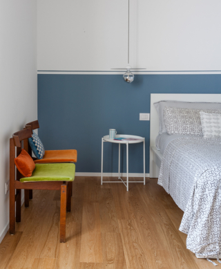 Tondo ed essenziale, il tavolino bianco in metallo contrasta sullo sfondo della boiserie dipinta di azzurro polvere Tondo ed essenziale, il tavolino bianco in metallo contrasta sullo sfondo della boiserie dipinta di azzurro polvere