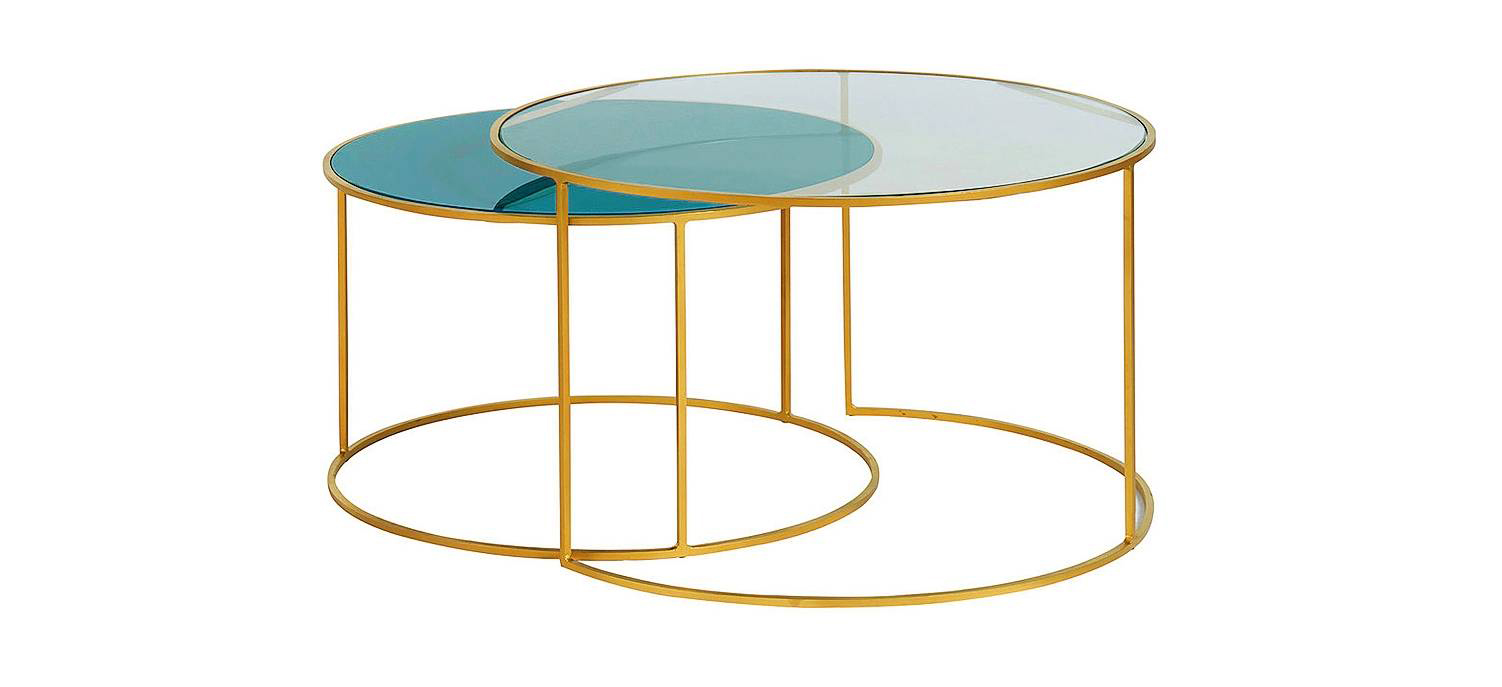 I tavolini estraibili Roxo di Miliboo hanno la struttura in metallo dorato e i piani in vetro trasparente e blu petrolio. Misurano Ø 65 x H 39 cm e Ø 75 x H 44,3 cm. Il set costa 419,99 euro. www.miliboo.it