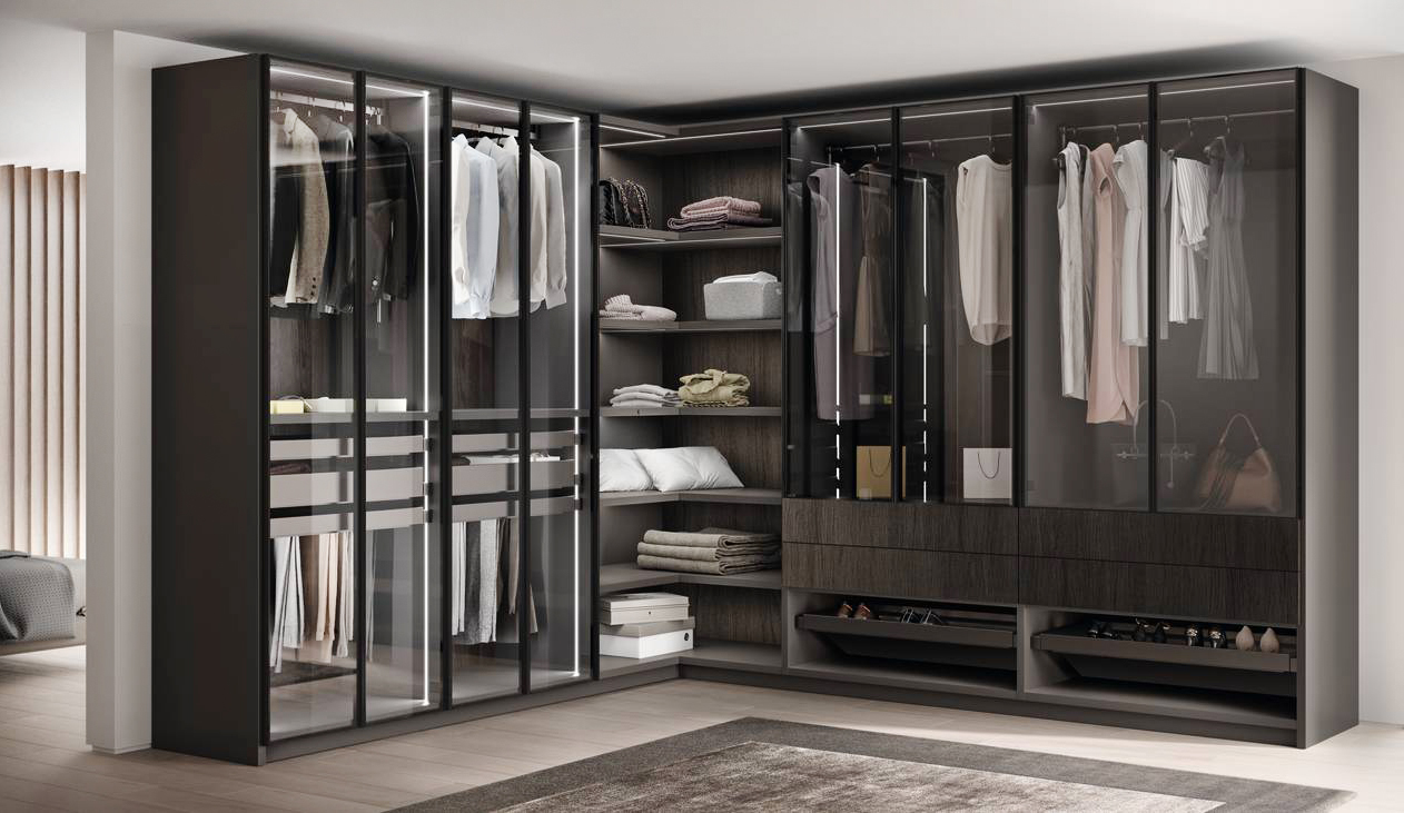 Le ante in vetro Fumé trasparente, dotate di telaio in metallo nella finitura Grigio Antracite e maniglie integrate, caratterizzano l'armadio ad angolo Walk-in Fluida di Scavolini che ha lo schienale in Impiallacciato Rovere Carbone. Gli accessori interni Support nella finitura Metal Grey, come appendiabiti, vassoio multiuso, porta orologi e portagioie, aste porta pantaloni, porta scarpe, e  il sistema di illuminazione Magical completano la composizione. Prezzo su richiesta. www.scavolini.com Le ante in vetro Fumé trasparente, dotate di telaio in metallo nella finitura Grigio Antracite e maniglie integrate, caratterizzano l'armadio ad angolo Walk-in Fluida di Scavolini che ha lo schienale in Impiallacciato Rovere Carbone. Gli accessori interni Support nella finitura Metal Grey, come appendiabiti, vassoio multiuso, porta orologi e portagioie, aste porta pantaloni, porta scarpe, e  il sistema di illuminazione Magical completano la composizione. Prezzo su richiesta. www.scavolini.com