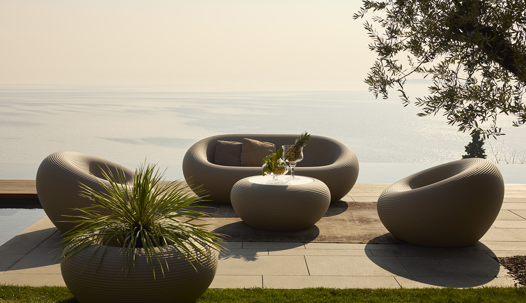 Fanno parte della collezione Nami di Qeeboo gli arredi da esterno con una forma arrotondata e avvolgente, completamente realizzati in polietilene riciclabile: un tavolino, un vaso, una poltrona e un divano coordinati.  https://www.qeeboo.com - Salone del Mobile, padiglione 10, stand S43.