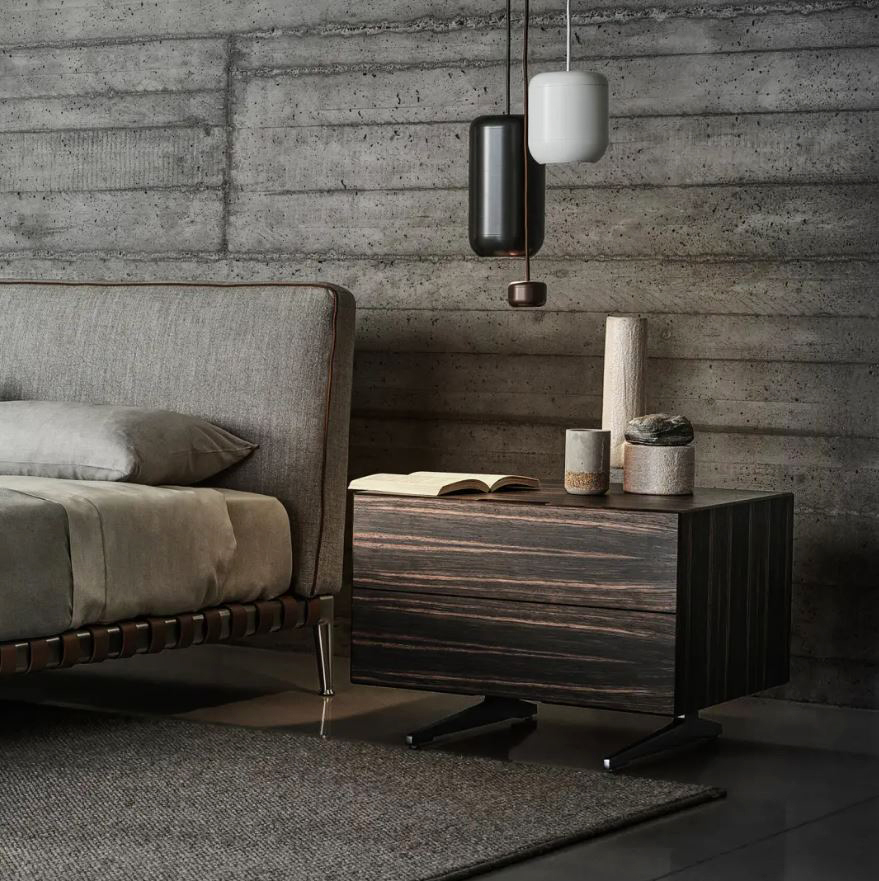 Ha una forma rigorosa che mette in evidenza il legno e le sue venature il comodino Piuma di Flexform, designer Antonio Citterio: ha la struttura con due cassetti realizzata in essenze pregiate come il noce e l'ebano. I piedi in alluminio sono disponibili in cinque finiture diverse. Misura L 60 x P 55 x H 48 cm. Prezzo su richiesta. https://www.flexform.it