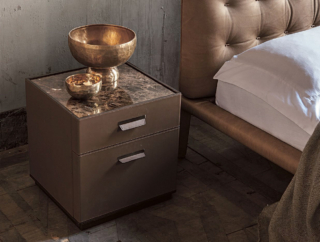 Un pregiato rivestimento in cuoio con cucitura decorativa per il comodino Skin di Alivar, designer Giuseppe Bavuso, che ha la struttura realizzata in rovere termotrattato o in noce nazionale. I due cassetti sono dotati di maniglie in metallo rivestite in cuoio e di guide metalliche frenanti. Il piano è disponibile in marmo o in cuoio. Misura L 45 x P 43 x H 48 cm. Prezzo su richiesta. https://www.alivar.it