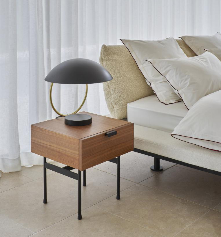 È stato disegnato nel 1954 il comodino Tanis di Ligne Roset, designer Pierre Paulin, che è caratterizzato dalla struttura con un cassetto nella finitura noce e da quattro sostegni in tubolare metallico nero. Misura L 42 x P 43,6 x H 45,3 cm. Prezzo 1.069 euro. https://www.ligne-roset.com