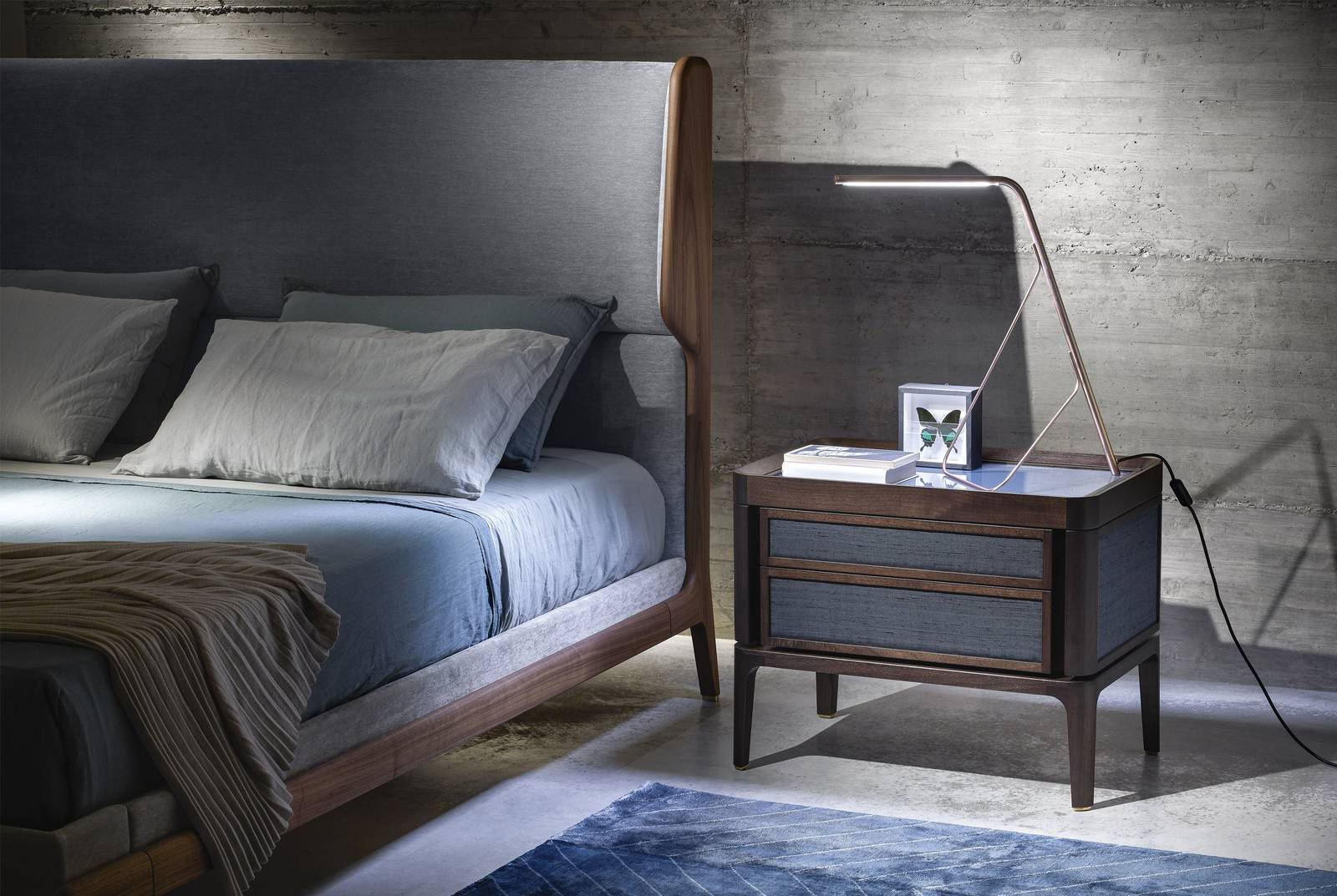 Una struttura in massello di noce americano per il comodino Full di Ceccotti Collezioni, designer Roberto Lazzeroni, che ha i frontali dei due cassetti e i pannelli laterali impreziositi da un rivestimento in tessuto. Il piano è personalizzabile: in legno, in vetro colorato o in marmo. Misura L 71 x P 45 x H 52 cm. Prezzo su richiesta. https://www.ceccotticollezioni.it