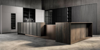 Viene presentata in anteprima durante il Fuorisalone la nuova cucina Tai_o di Key Cucine che si sviluppa intorno all'isola, racchiusa e protetta da moduli lignei in rovere fossile millenario e da elementi in peltro bronzato rivestiti in marmo Clauzetto , con una planimetria a L che separa e distanzia la zona lavoro dal living. Le colonne attrezzate e la boiserie che “vestono” le pareti sono cannettate in legno massello. https://www.keysbabo.com - Fuorisalone, Showroom Milano c/o Agape 12  – Via Statuto 12, Milano