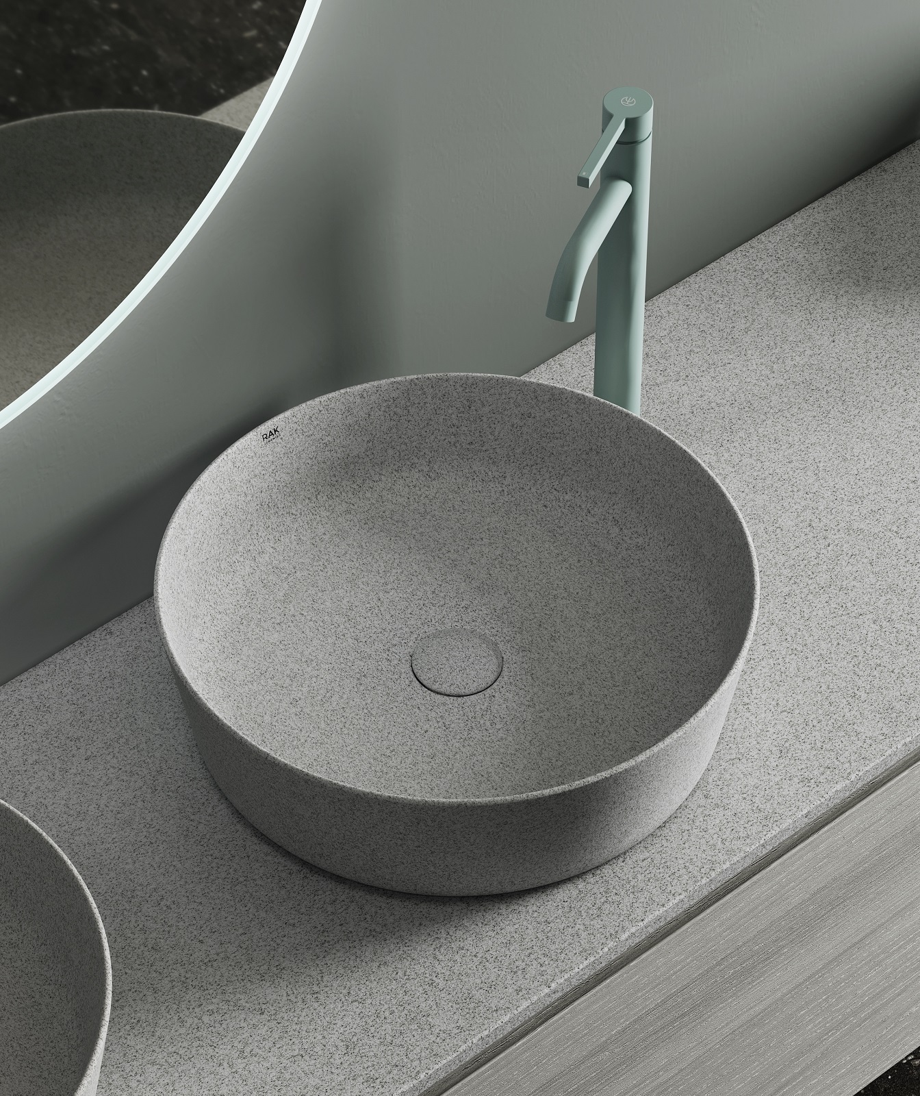 La collezione di lavabi RAK-BATU di Rak Ceramics è realizzata con uno smalto artistico ottenuto aggiungendo all'impasto particelle di Mica.‎ I lavabi sono rotondi, ovali e rettangolari.‎ Abbinate a materiali naturali come legno, pietra e rattan, le tre finiture - Mica White, Mica Warm Grey e Mica Cool Grey - infondono al bagno una calda atmosfera. RAK-PLANO è un piano unico, privo di giunture che può essere forato e tagliato direttamente durante l’installazione ed è realizzato in diversi materiali tra cui la finitura Mica. In foto il lavabo rotondo RAK-BATU, con diametro di 42 cm, nella finitura Mica Cool Grey e top RAK-Plano nella stessa finitura Mica. www.rakceramics.com – Salone del Mobile, padiglione 06, stand A30.