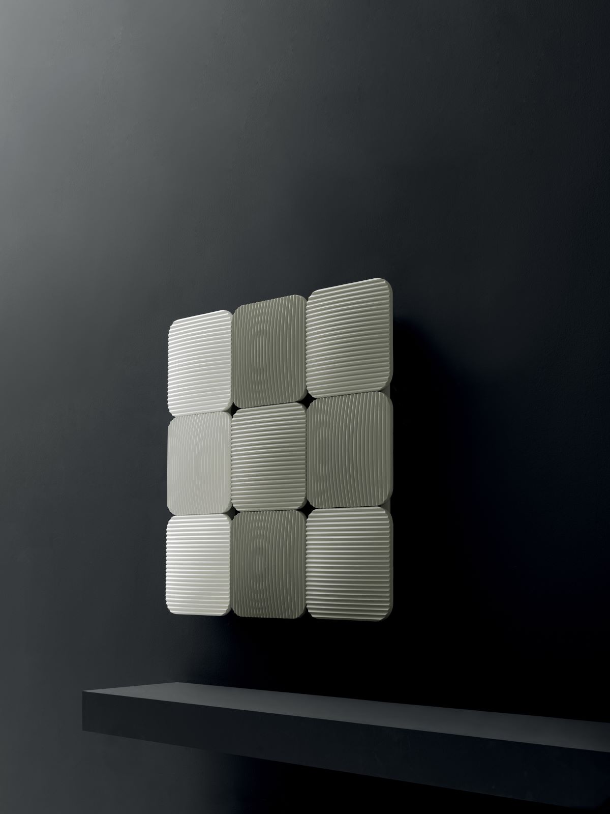Il radiatore modulare Lana di Antrax IT si sviluppa a partire da una formella quadrata di 33 x 33 cm, con angoli stondati ed effetto bombato. Realizzata in fusione di alluminio 100% riciclabile, permette di realizzare svariate configurazioni. La superficie curva è ulteriormente lavorata con una plissettatura superficiale, inspirata ai morbidi filati del mondo tessile cui rimanda anche l’elegante patchwork dato dall’accostamento di più moduli, orientati in orizzontale o verticale. Deriva da qui il nome della collezione. Il radiatore è personalizzabile nelle cromie e nella configurazione: da un minimo di tre elementi, lineari, a un massimo di dodici, organizzati su due file e con pattern alternato. In questo modo si può dare vita a composizioni affiancate di più modelli, in continuità, sfalsati o raggruppati in un formato quadrato. La matrice dalla quale prende vita il termoarredo è disegnata per aumentare la capacità radiante: il motivo a plissé offre una duplice valenza decorativa e funzionale e permettere di raggiungere elevate prestazioni termiche nelle versioni elettrica e idraulica. È disegnato da AMDL CIRCLE e accessoriabile anche con un maniglione su cui sistemare le salviette che ne agevola l’impiego nell’ambiente bagno. www.antrax.it – Salone del Mobile, padiglione 6, stand A31.