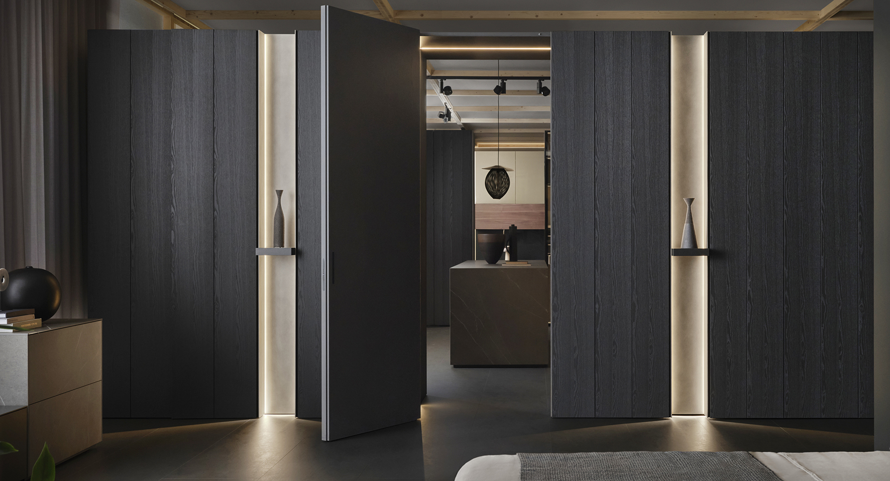 È composto da due elementi in continuo dialogo tra loro, la boiserie e la porta, il sistema Architype di Caccaro che permette di organizzare lo spazio senza bisogno di muratura; inoltre, può essere bifacciale ed è dotato di una morbida illuminazione d'atmosfera integrata. La finitura natural wood nero stout lo rende scenografico ed elegante. https://www.caccaro.com - Salone del Mobile, padiglione 22, stand M22-M24.