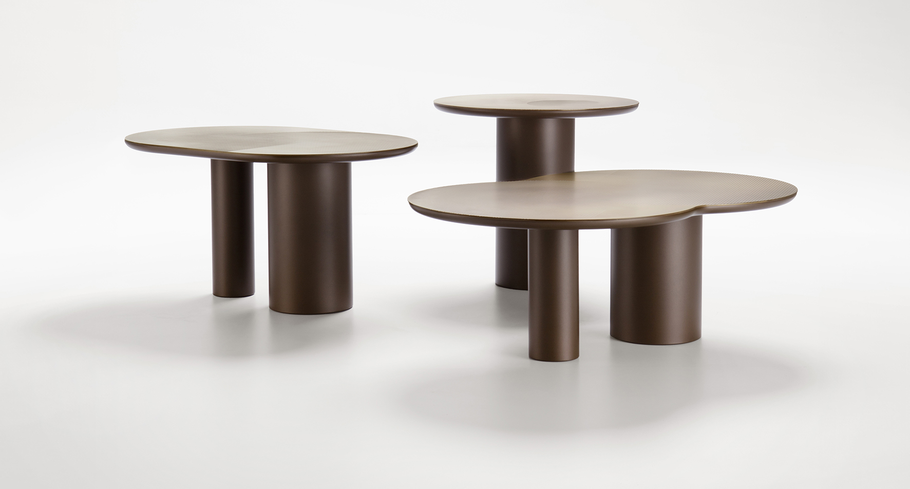 I tavolini della collezione Flocks di De Castelli sono realizzati in lastra di ottone o rame e sono composti da uno o due cilindri per la base e da un piano circolare con un pattern grafico sulla superficie ottenuto con la finiture DeErosion che regala una sensazione tattile tridimensionale. Sono disponibili in tre diverse forme e altezze. Misurano Ø 50 x H 45 cm, L 75 x P 50 x H 38 cm e L 89 x P 58 x H 32 cm. https://www.decastelli.com  - Salone del Mobile, padiglione 24, stand B01-B02.