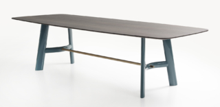 Il tavolo August di Lema ricorda i modelli da lavoro a cavalletto  della prima metà del Novecento: il piano dallo spessore sottile, disponibile in marmi o essenze diverse, poggia su due cavalletti collegati fra loro da un tenditore in finitura bronzo patinato e da un traverso leggermente curvato in legno. Le gambe del tavolo con forma ellittica sono disponibili con finitura laccata lucida e opaca. https://www.lemamobili.com - Salone del Mobile, padiglione 11, stand B15-C20.