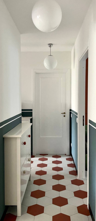 corridoio con piastrelle bicolor e boiserie