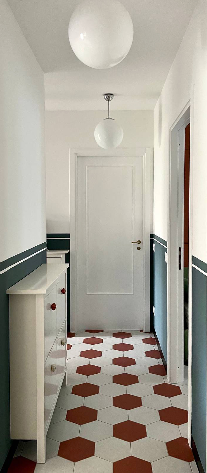 corridoio con piastrelle bicolor e boiserie