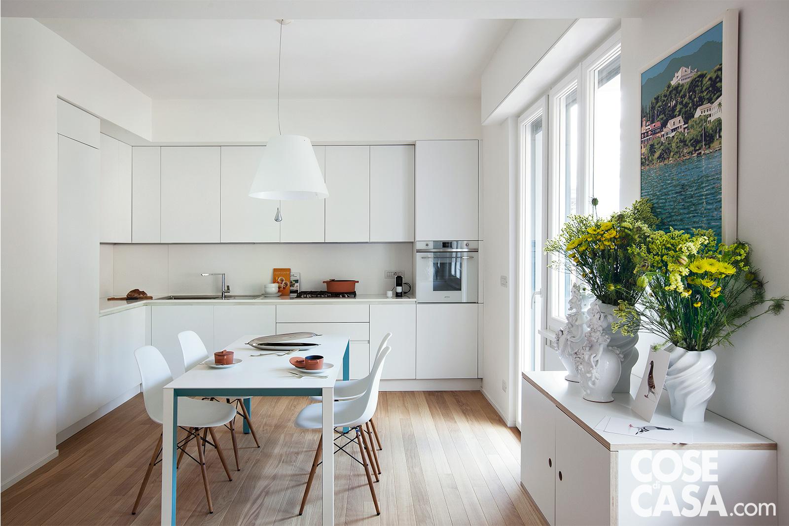 Nella zona pranzo, tra cucina e living, il tavolo rettangolare bianco è Shadow di De Padova con sedie DSW della serie Plastic Chair di Vitra, design Charles & Ray Eames. La composizione della cucina in laccato bianco opaco è di Gruppo Euromobil, il forno a colonna è di Smeg. Appoggiate sul piano del tavolo e sul top della zona operativa, la pesciera, le stoviglie e la pentola sono di Rosenthal/Sambonet. La lampada a sospensione è Costanza di Luceplan, design Paolo Rizzatto. Progetto Eugadesign Studio, arch. Eugenio Gargioni e arch. Paola Traversa, Milano, Tel. 02/36560931. Foto Cristina Galliena Bohman. Styling Rosaria Galli. Nella zona pranzo, tra cucina e living, il tavolo rettangolare bianco è Shadow di De Padova con sedie DSW della serie Plastic Chair di Vitra, design Charles & Ray Eames. La composizione della cucina in laccato bianco opaco è di Gruppo Euromobil, il forno a colonna è di Smeg. Appoggiate sul piano del tavolo e sul top della zona operativa, la pesciera, le stoviglie e la pentola sono di Rosenthal/Sambonet. La lampada a sospensione è Costanza di Luceplan, design Paolo Rizzatto. Progetto Eugadesign Studio, arch. Eugenio Gargioni e arch. Paola Traversa, Milano, Tel. 02/36560931. Foto Cristina Galliena Bohman. Styling Rosaria Galli.