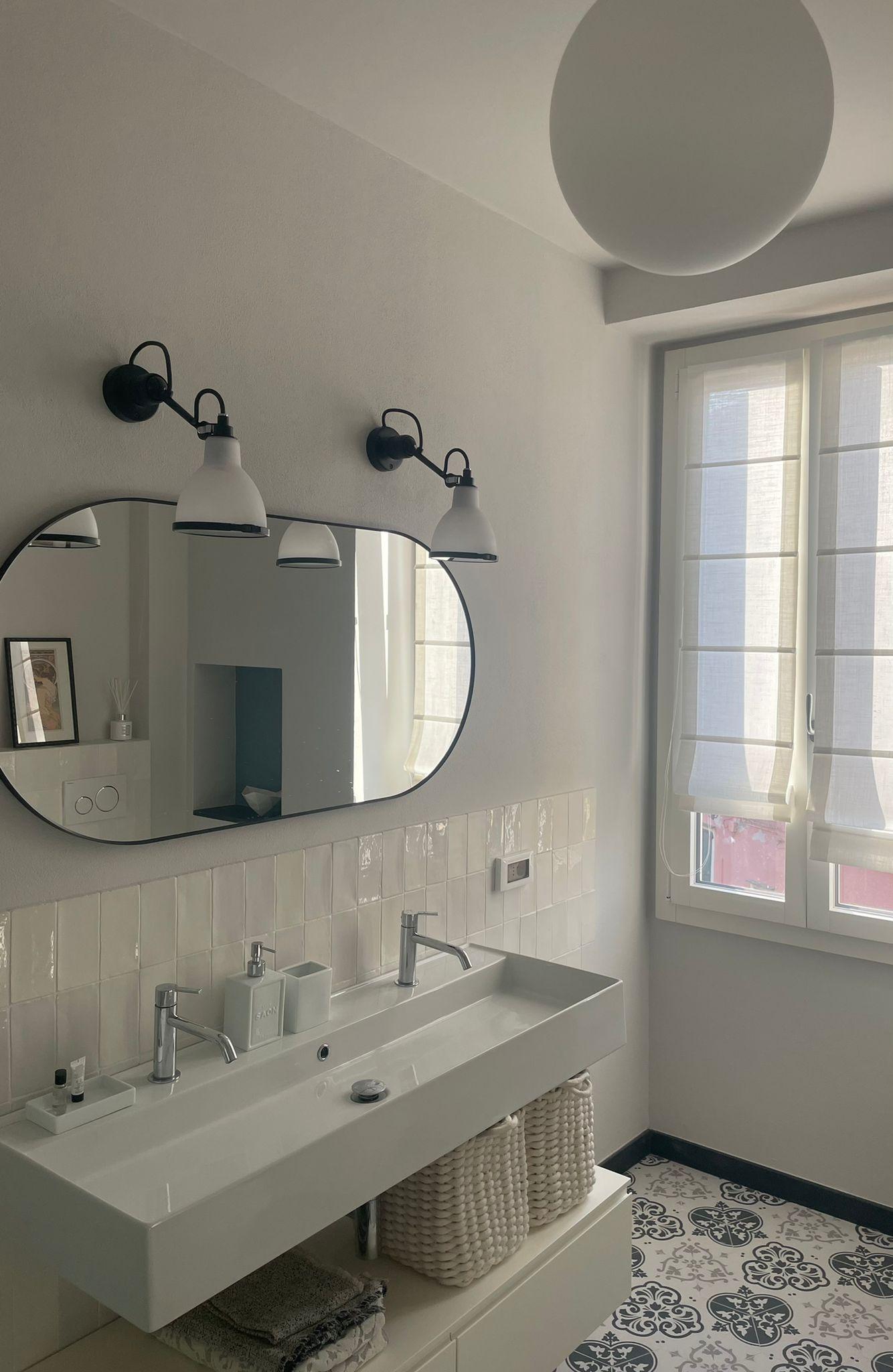 Il-bagno-piastrelle-bianche-a-parete-e-cementine-bianche-e-blu-a-terra