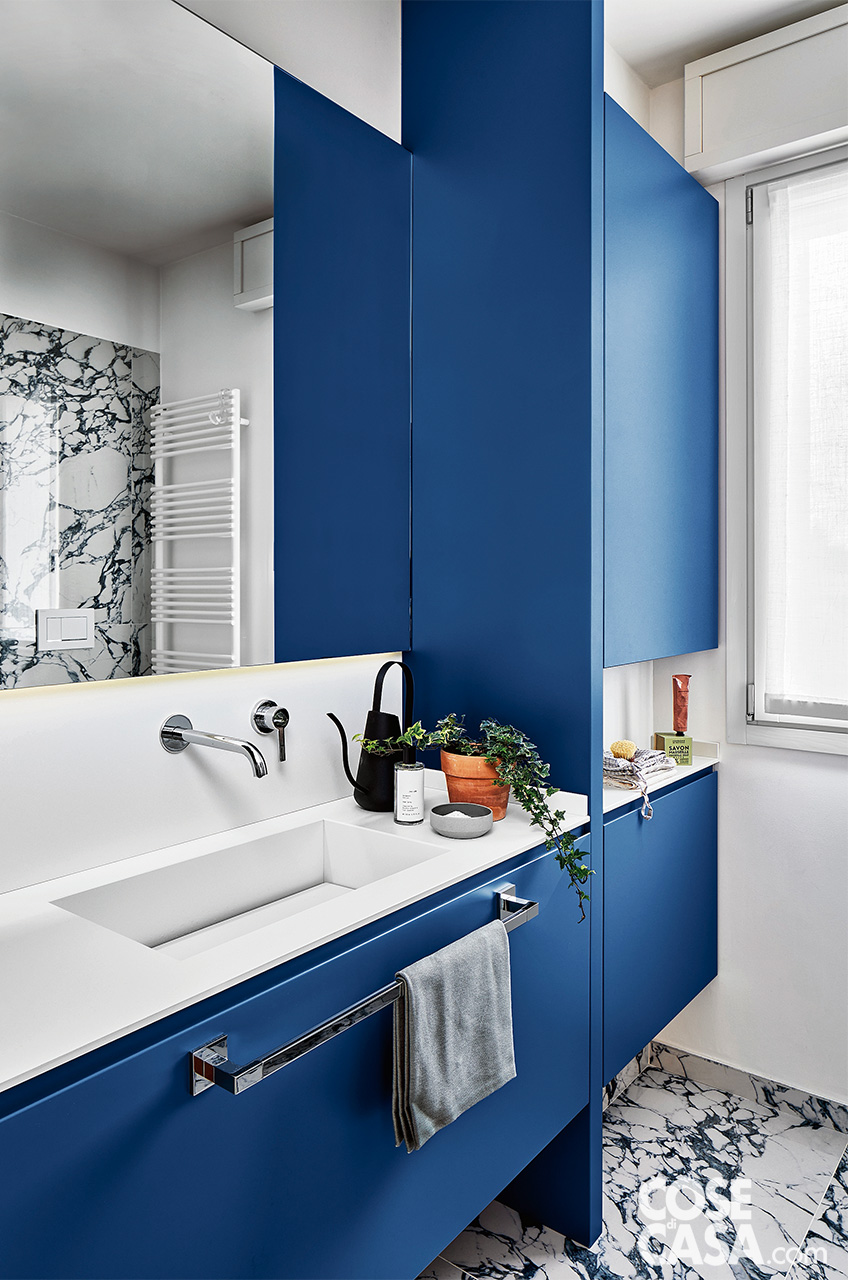 bagno bianco e blu, con mobile lavabo e colonna laterale; alzata nello stesso materiale del top sotto lo specchio bagno bianco e blu, con mobile lavabo e colonna laterale; alzata nello stesso materiale del top sotto lo specchio