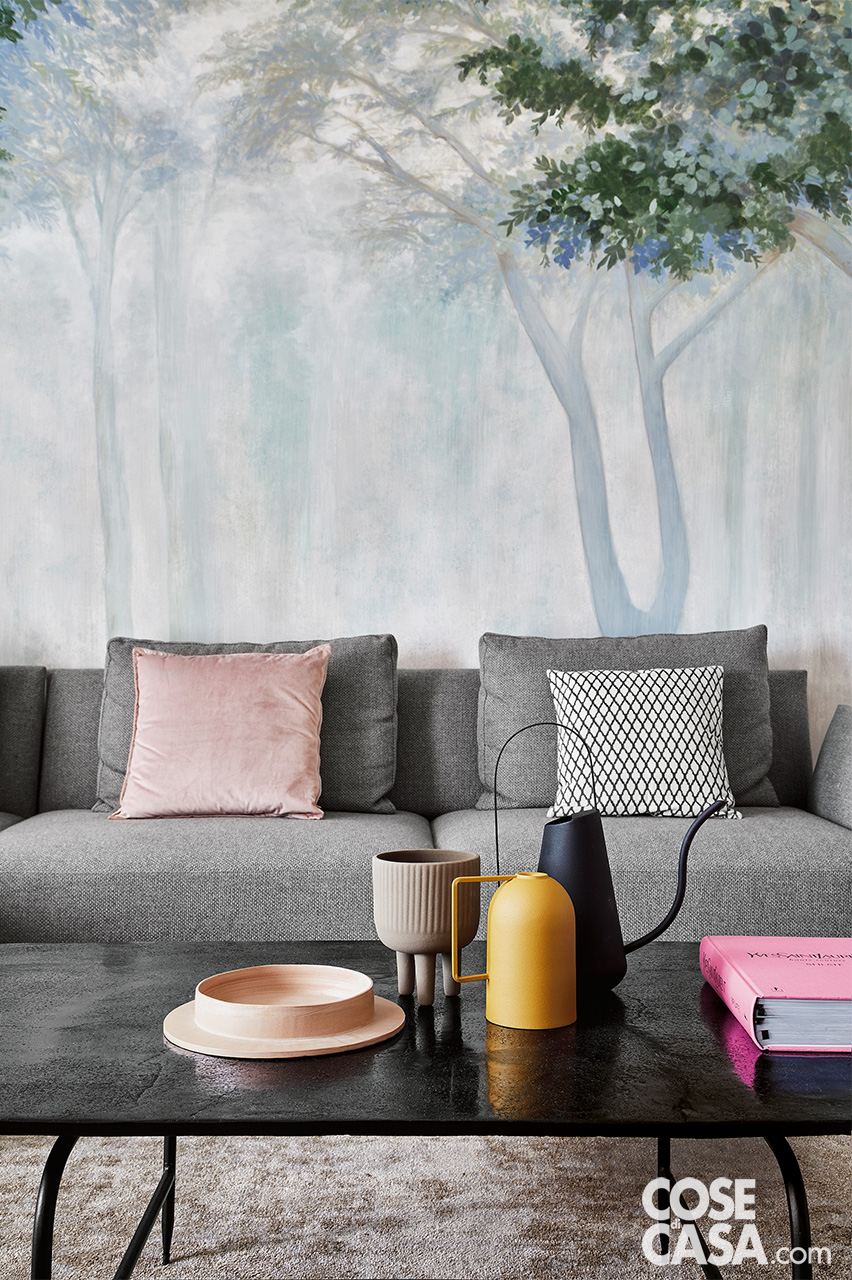 soggiorno con divano grigio  e cuscini d'arredo rosa e accessori colorati su tavolino soggiorno con divano grigio  e cuscini d'arredo rosa e accessori colorati su tavolino