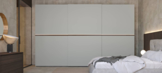 Ante scorrevoli in nobilitato color gesso, dotate di illuminazione a Led, per l'armadio New Slide di Giessegi che è facile da ambientare. Ogni modulo ha la seguente dotazione interna: un ripiano, due tubi appendiabiti ed ammortizzatori di serie per apertura e chiusura. Misura L 413,8 x P 61/66 x H 262 cm. Prezzo 4.696 euro + Iva. www.giessegi.it