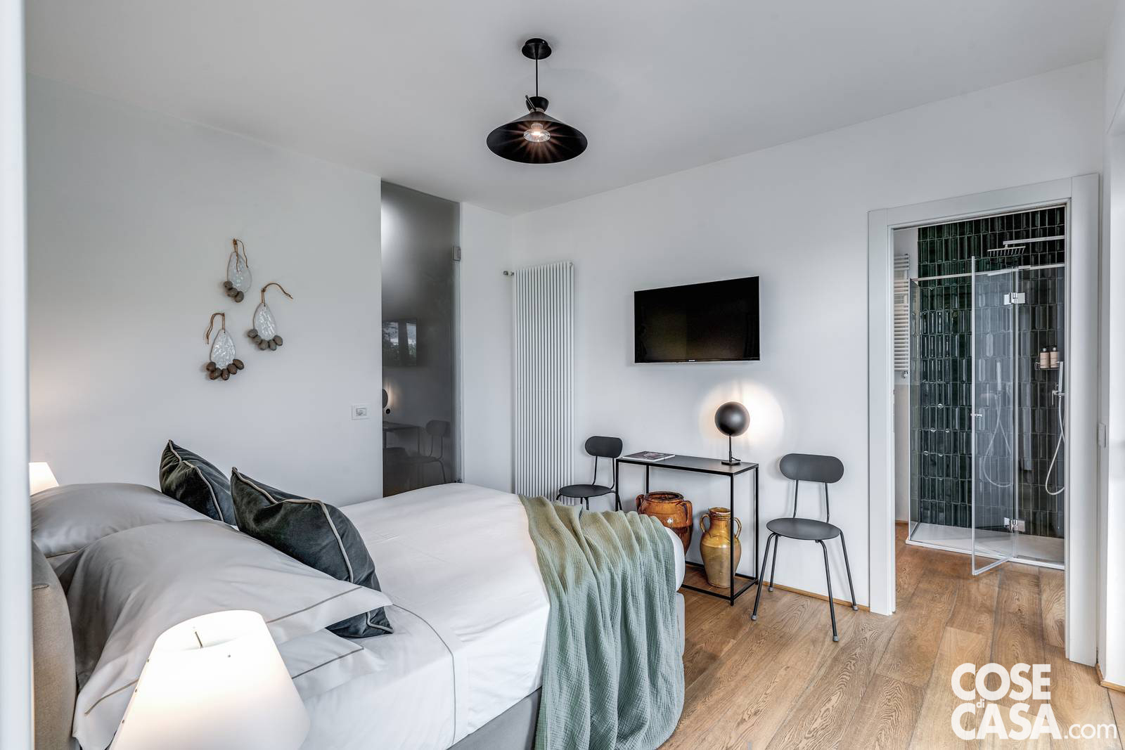 Di fronte al letto, la parete attrezzata con la TV si integra con discrezione nell’ambiente, sottolineando l’essenzialità dell’arredo e la volontà di mantenere un’atmosfera ordinata e luminosa. Di fronte al letto, la parete attrezzata con la TV si integra con discrezione nell’ambiente, sottolineando l’essenzialità dell’arredo e la volontà di mantenere un’atmosfera ordinata e luminosa.