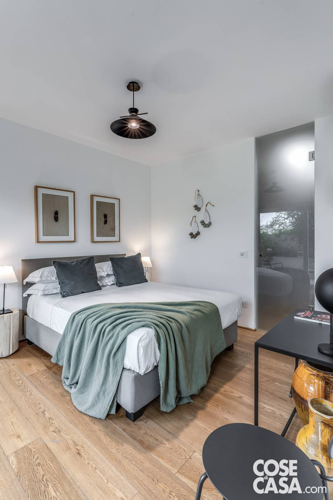 La camera da letto principale è arredata con pezzi iconici e naturali, come i comodini in legno grezzo e la ceramica grottagliese, per un equilibrio tra design e artigianato locale. La camera da letto principale è arredata con pezzi iconici e naturali, come i comodini in legno grezzo e la ceramica grottagliese, per un equilibrio tra design e artigianato locale.