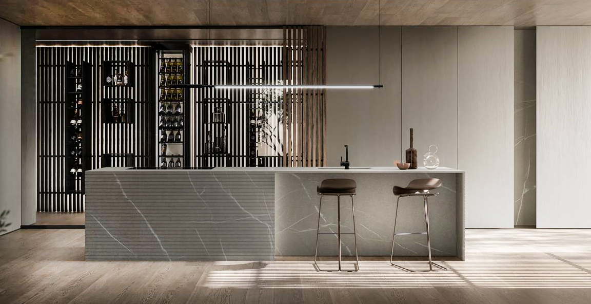 Fa parte del programma Blade Lab di Modulnova l'imponente isola in pietra Piasentina fiammata impreziosita dalla lavorazione millerighe e da una luce integrata nel blocco che mette in risalto la matericità della pietra. Le colonne Blade Laccato Metal Ivory terra soffitto e la grande cantina, protetta da una parete vetrata grigio fumè con anta a bilico, completano la composizione. Prezzo su richiesta. www.modulnova.it