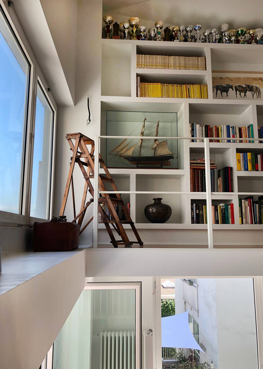 Libreria in cartongesso sul soppalco con vani di misura diversi Libreria in cartongesso sul soppalco con vani di misura diversi
