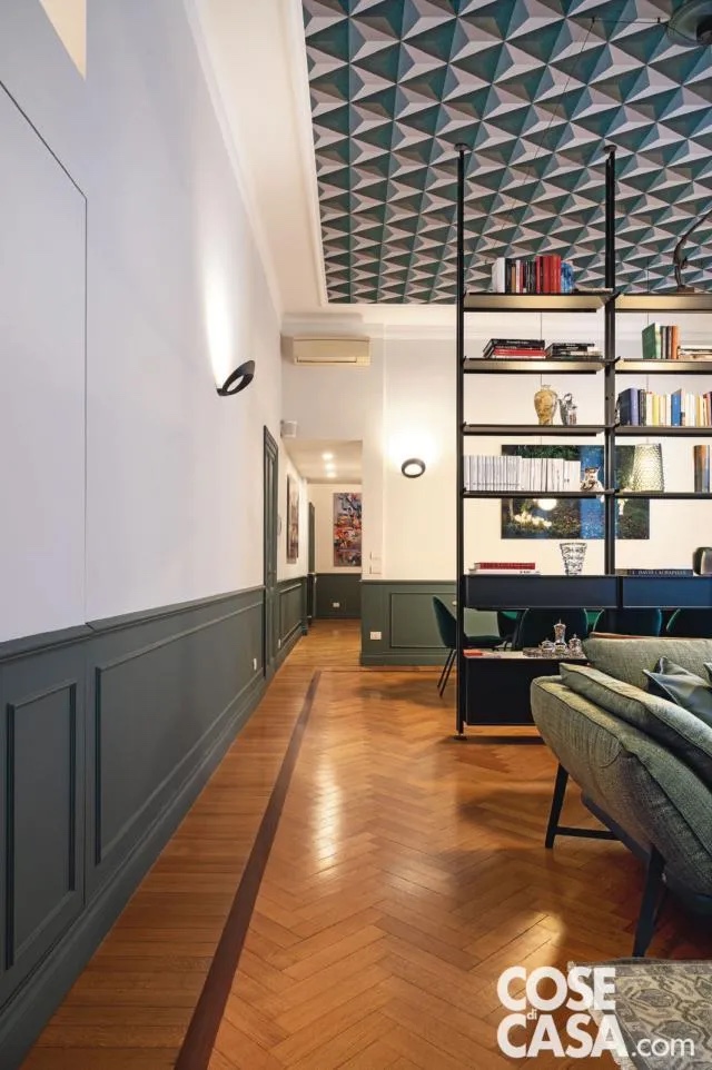 Nel soggiorno, il committente ha scelto un divano angolare dalle linee contemporanee e dalle dimensioni generose: un mix intrigante di pelle e tessuto sui toni del verde che riprende i colori usati nell’arredo dell’intero living. In particolare: sulla boiserie (dal battiscopa alto e i profili importanti) e sulla carta da parati a soffitto. Nel soggiorno, il committente ha scelto un divano angolare dalle linee contemporanee e dalle dimensioni generose: un mix intrigante di pelle e tessuto sui toni del verde che riprende i colori usati nell’arredo dell’intero living. In particolare: sulla boiserie (dal battiscopa alto e i profili importanti) e sulla carta da parati a soffitto.