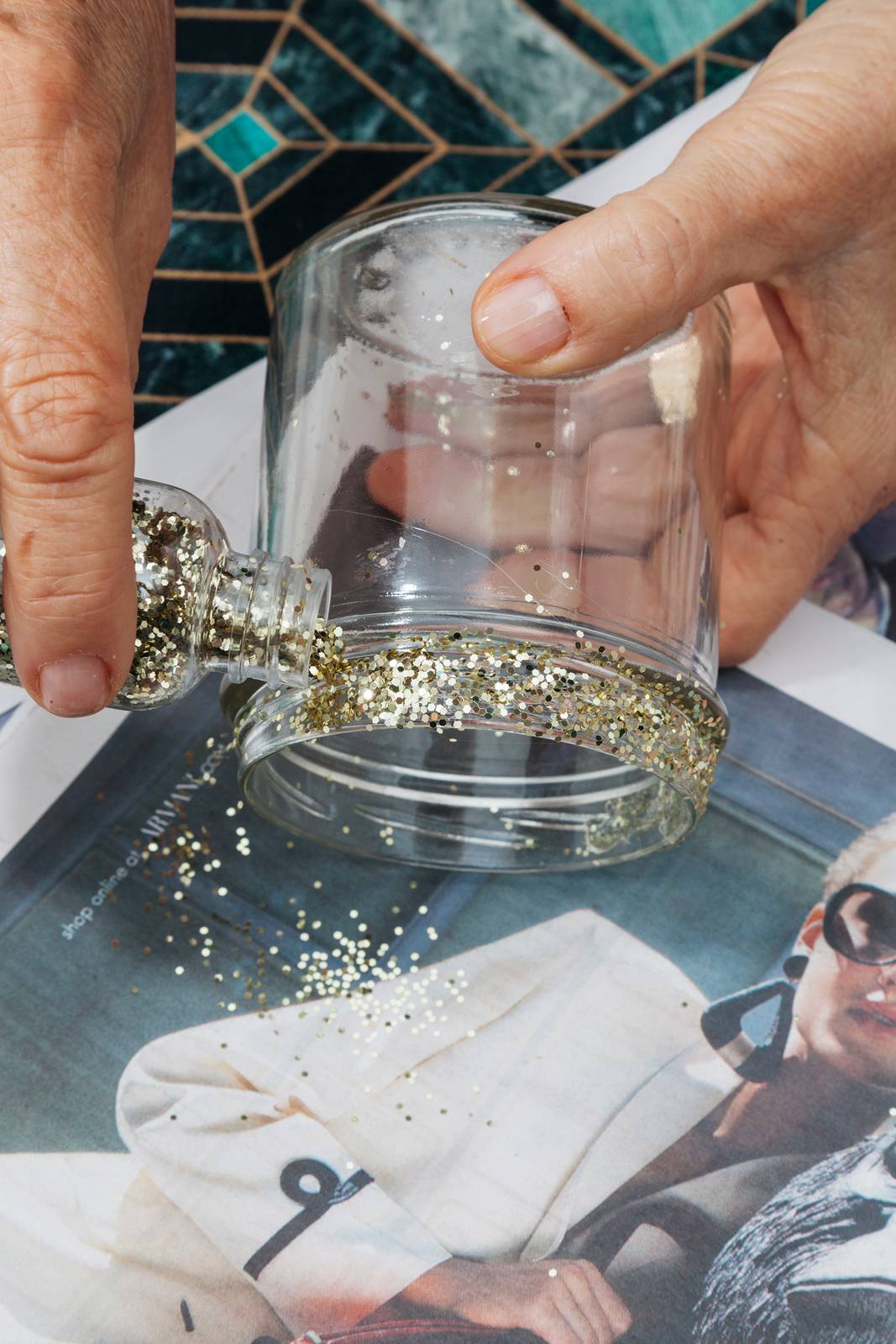 Cospargere la porporina dorata sul velo di colla pre creare il bordo glitterato Cospargere la porporina dorata sul velo di colla pre creare il bordo glitterato