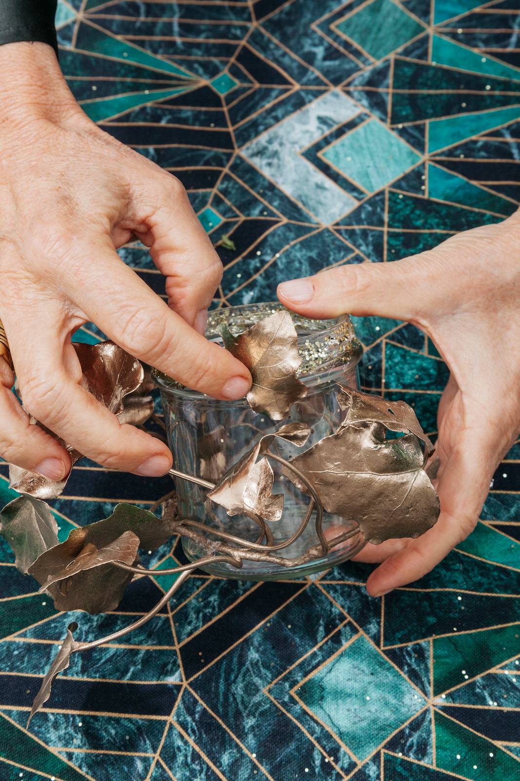 Far aderire al vetro alcune foglie di edera applicando qualche goccia di colla a caldo Far aderire al vetro alcune foglie di edera applicando qualche goccia di colla a caldo