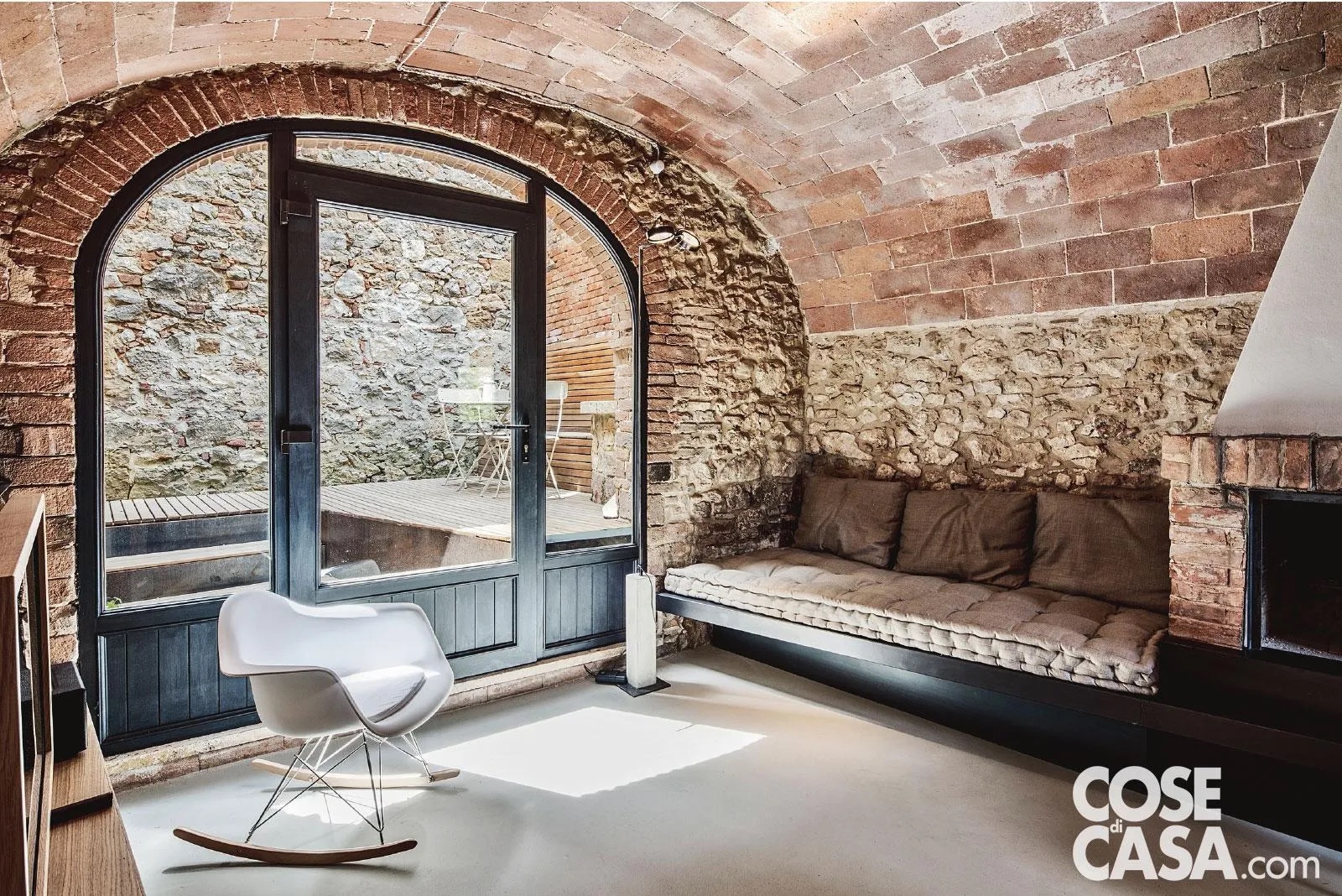 La parete del soggiorno con volta a botte dietro al divano è rivestita in pietra. Foto: Davide Galli. Progetto: Diego Cisi e Stefano Gorni Silvestrini – ArchiplanStudio, archiplanstudio.com