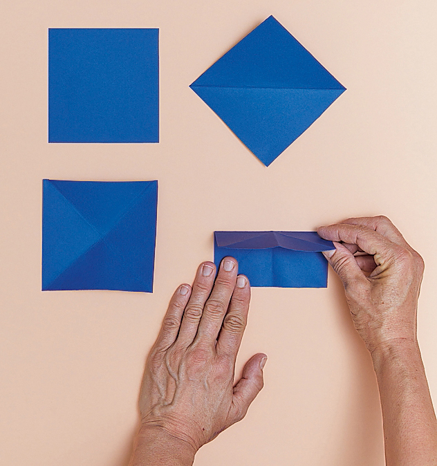1. Dal cartoncino leggero blu ritagliare due foglietti quadrati di 10 cm di lato (il formato può, però, variare in base al gusto personale). Piegare il primo foglietto seguendo le diagonali, prima
in un verso e poi nell’altro. Quindi piegare
il foglietto a metà unendo prima due lati e poi gli altri due, premendo con le dita
per marcare bene la piega. 1. Dal cartoncino leggero blu ritagliare due foglietti quadrati di 10 cm di lato (il formato può, però, variare in base al gusto personale). Piegare il primo foglietto seguendo le diagonali, prima
in un verso e poi nell’altro. Quindi piegare
il foglietto a metà unendo prima due lati e poi gli altri due, premendo con le dita
per marcare bene la piega.