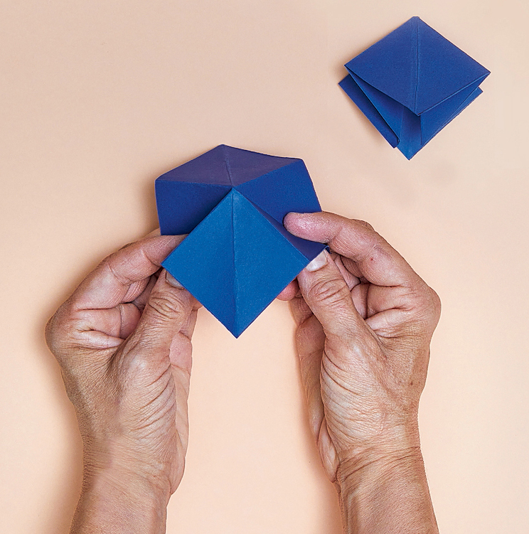 2. Seguire la stessa procedura per entrambi i foglietti. Aprire il primo
e spingere verso l’interno
le pieghe diagonali, così da ricavare
una sagoma a forma di rombo. 2. Seguire la stessa procedura per entrambi i foglietti. Aprire il primo
e spingere verso l’interno
le pieghe diagonali, così da ricavare
una sagoma a forma di rombo.