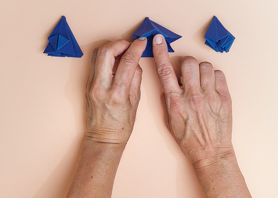 6. Aprire le pieghe e farle rientrare verso l’interno.
Girare il foglietto sull’altro lato e ripetere l’operazione, fino a ripiegare tutti gli angoli verso il centro, fino a ottenere la sagoma finale di questa foto. 6. Aprire le pieghe e farle rientrare verso l’interno.
Girare il foglietto sull’altro lato e ripetere l’operazione, fino a ripiegare tutti gli angoli verso il centro, fino a ottenere la sagoma finale di questa foto.