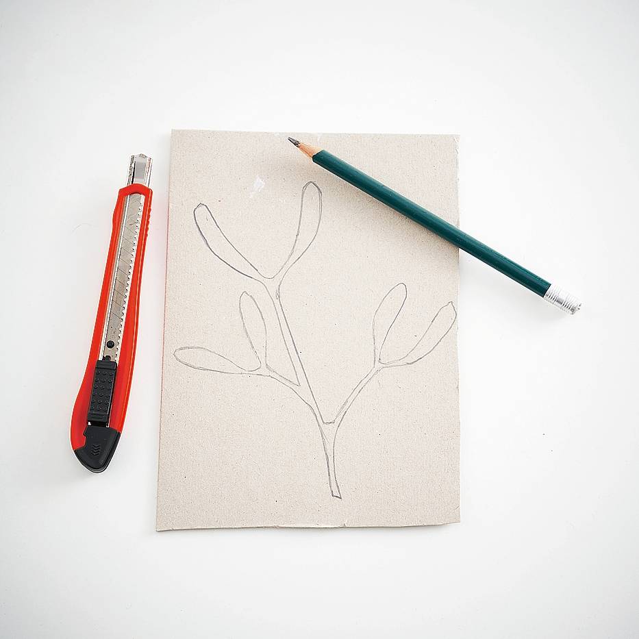 Recuperare on line le immagini del vischio, stamparle e disegnarle su un foglio di  cartoncino a mano libera se si è abbastanza esperti oppure con l’aiuto della carta
carbone o di un foglio di acetato. Appoggiare
il disegno su un tappetino da taglio
o in alternativa su un vecchio tagliere
o un'asse di legno. Con il cutter, incidere
i profili procedendo con precisione per
non rischiare di rovinare la mascherina.