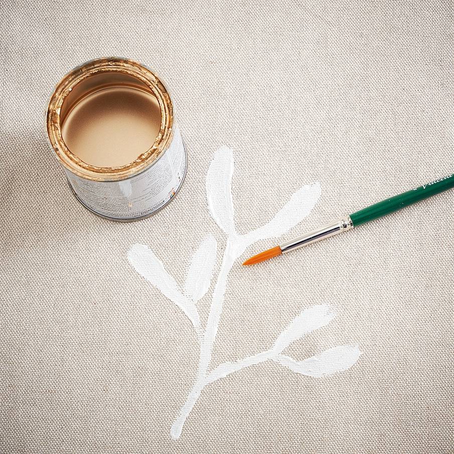 Ad asciugatura completa, rifinire i rametti di vischio disegnando a mano libera con
il pennello a punta tonda le bacche dorate: basta realizzare dei pallini all'incrocio delle foglie. Per arricchire la decorazione, con
il colore bianco disegnare qua e là su tutta
la superficie dei puntini bianchi effetto neve.