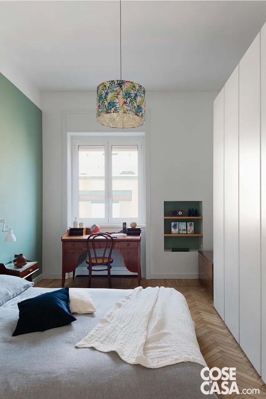 Nella camera matrimoniale, la parete è tinteggiata color verde lichene con smalti di Sikkens. La scrivania, la sedia Thonet e i comodini sono pezzi vintage; l’applique bianca orientabile è Luxi WO di Rotaliana, acquistata su Archiproducts. Il letto è un futon, mentre l’armadio è stato realizzato su misura. La lampada a sospensione centrale con paralume in tessuto è di Habitat. Nella camera matrimoniale, la parete è tinteggiata color verde lichene con smalti di Sikkens. La scrivania, la sedia Thonet e i comodini sono pezzi vintage; l’applique bianca orientabile è Luxi WO di Rotaliana, acquistata su Archiproducts. Il letto è un futon, mentre l’armadio è stato realizzato su misura. La lampada a sospensione centrale con paralume in tessuto è di Habitat.