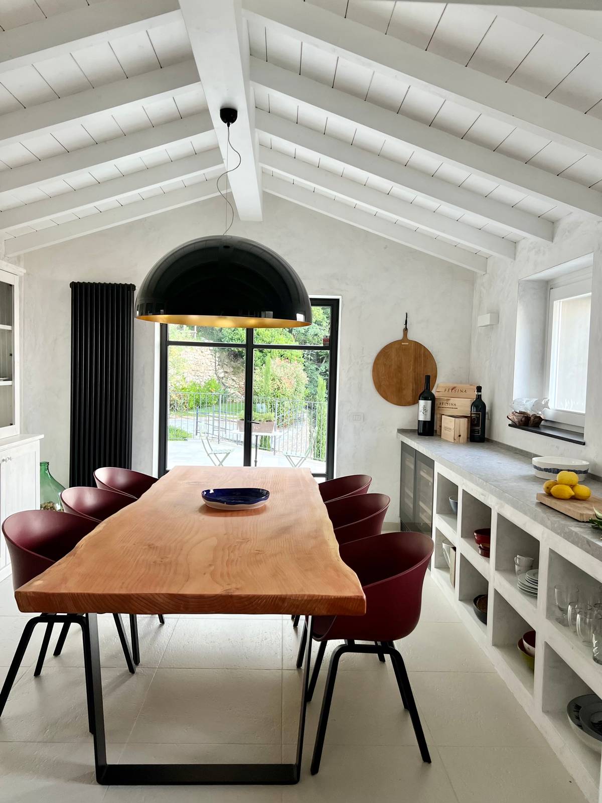 La cucina in muratura con piano in gres e il grande tavolo da pranzo con piano in legno La cucina in muratura con piano in gres e il grande tavolo da pranzo con piano in legno